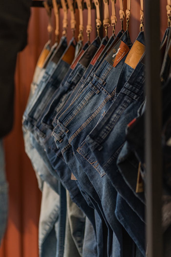 services-03 Close-up of blue denim jeans on hangers in a fashion store.