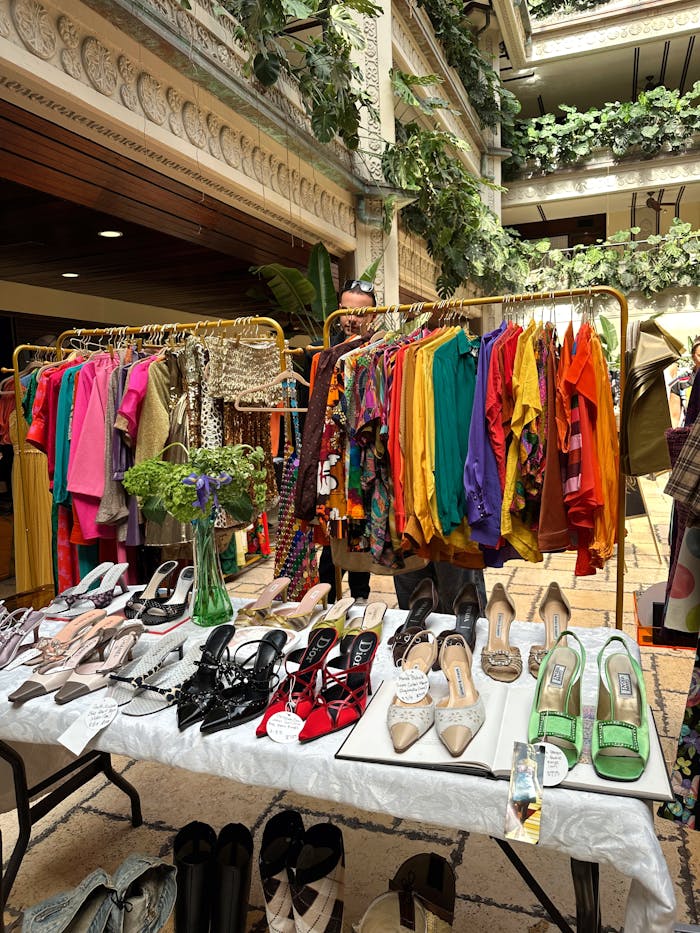 services-04 Vibrant vintage clothing and shoes displayed indoors with lush greenery.